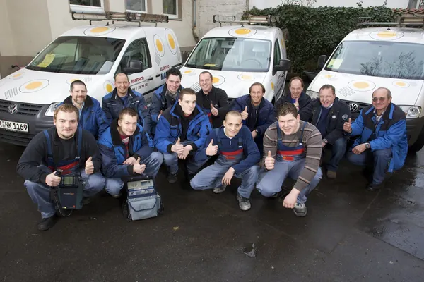 Gruppenbild des Teams vor drei Montagefahrzeugen