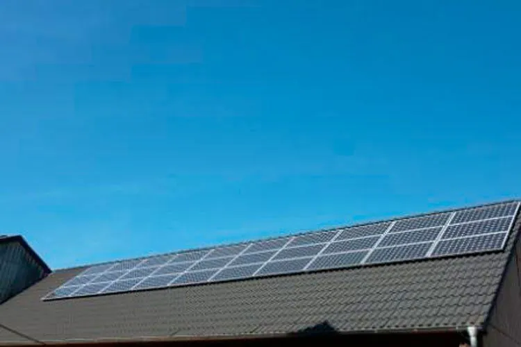 Dachflächen mit Solarmodulen unter blauem Himmel