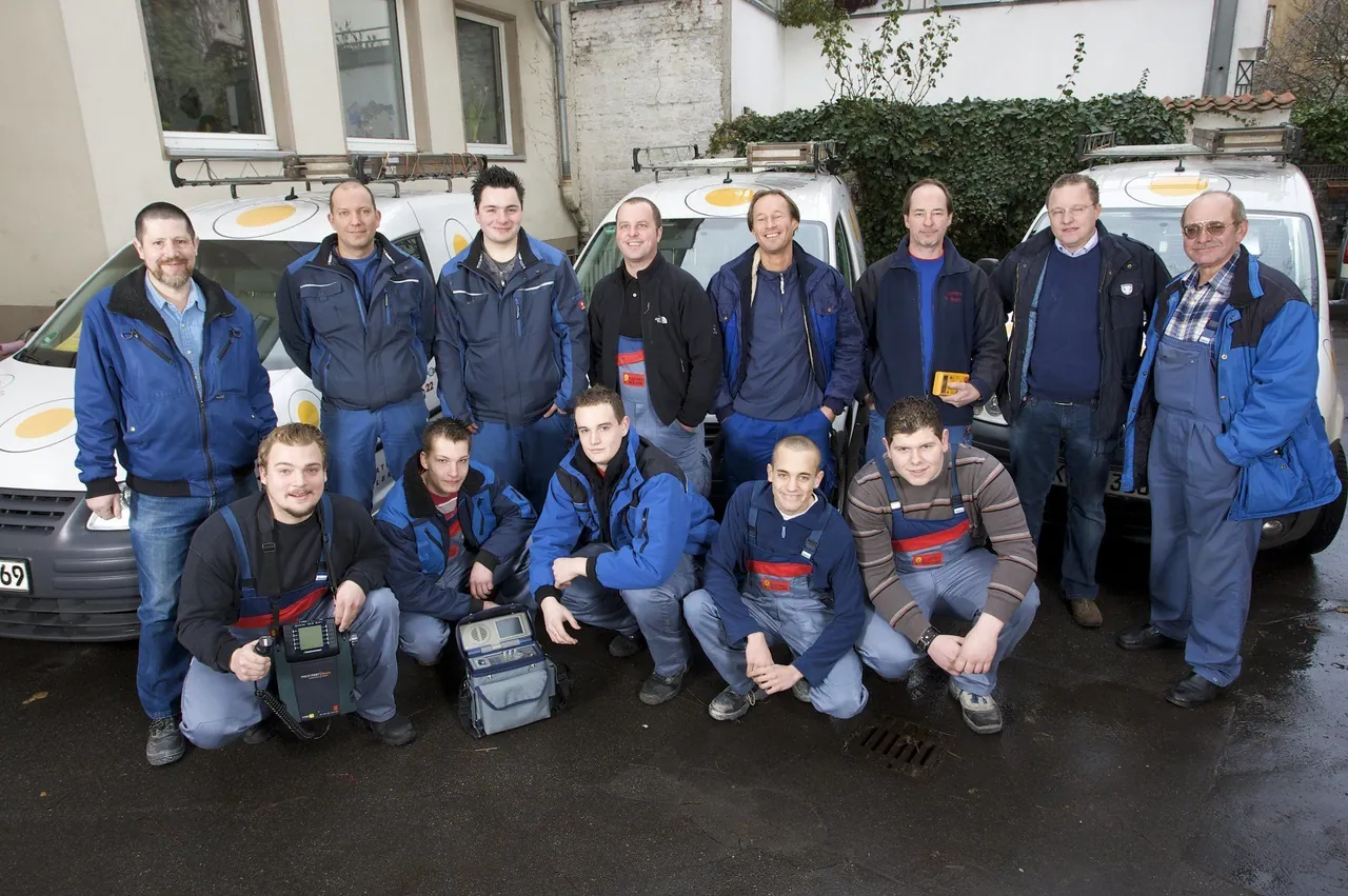Die Belegschaft von Elektro Martin Bolder vor den Montagefahrzeugen im Hof an der Alten Wallgasse